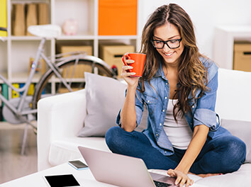 Girl with Orange Mug on laptop reading about public engagement